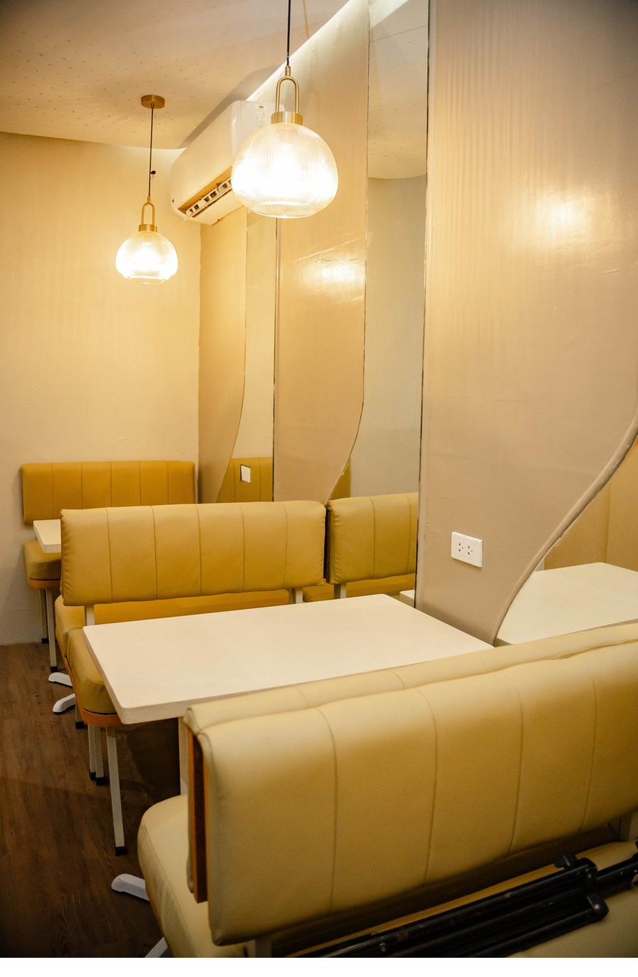 Cream banquette booths with pendant lights and mirrored partitions