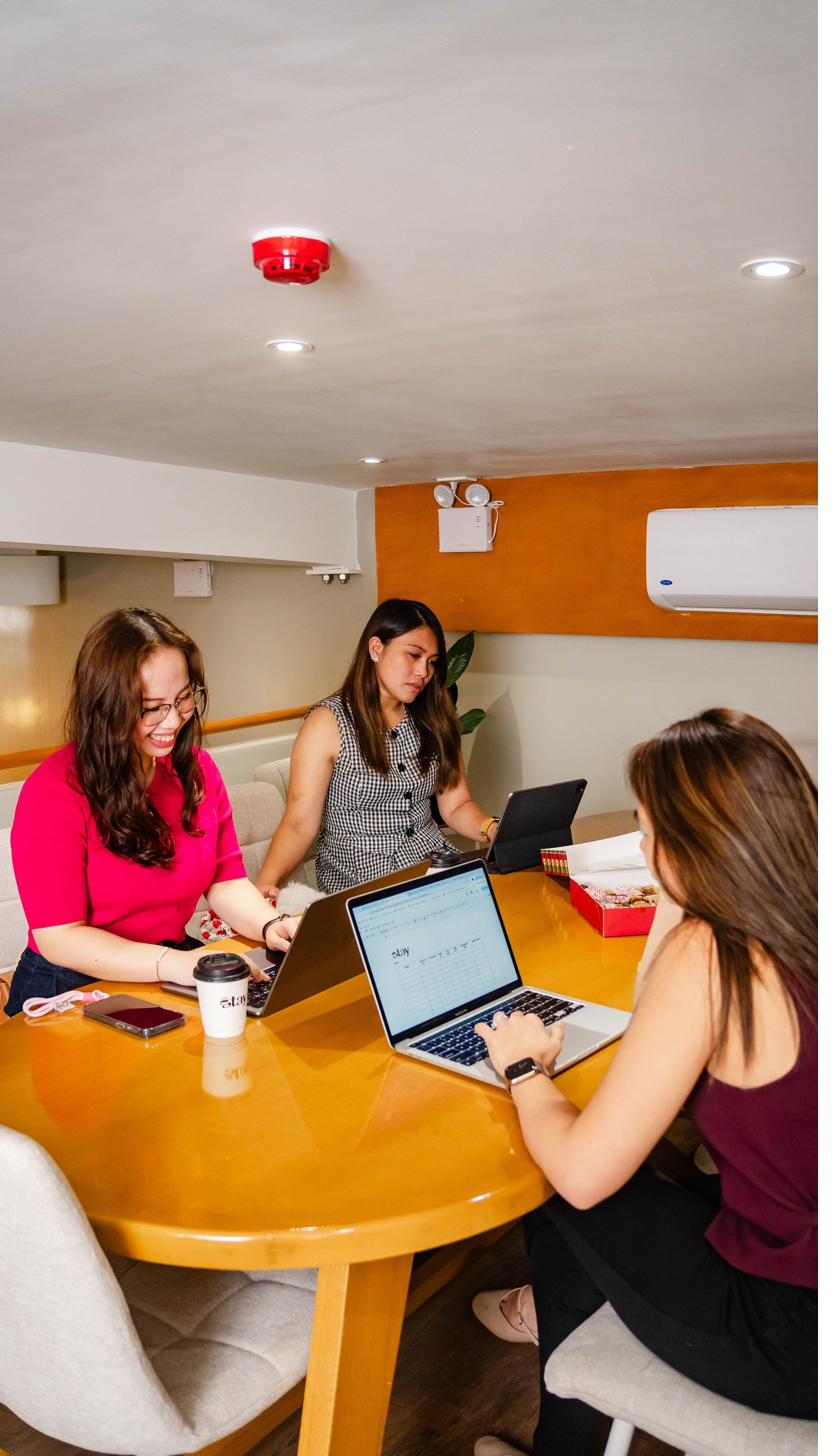 Branch 1 — three people working together at the table with a café stay cup