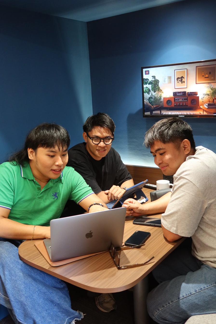 Co/Lab — three people collaborating in the blue booth