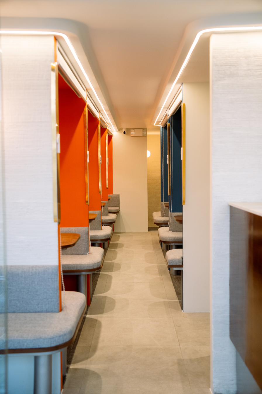 Corridor between orange and blue booths